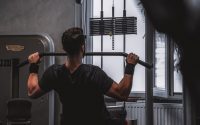 Back view of a man exercising with lat pulldown machine in the gym.